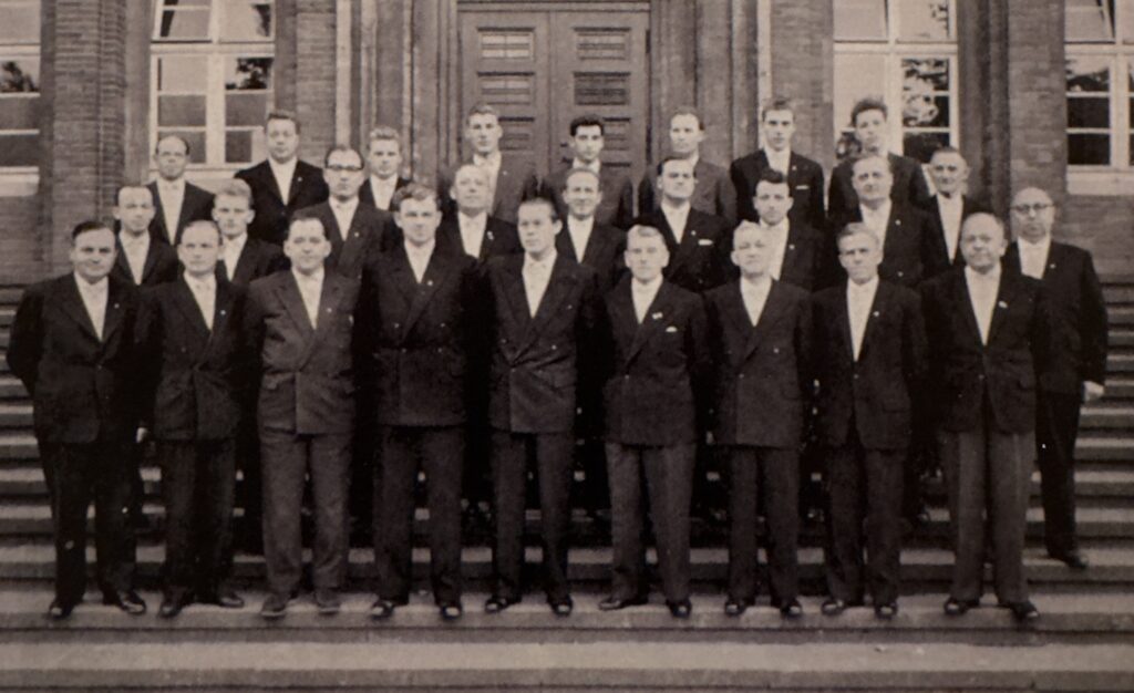 Vereinsfoto des Quartettvereins &sbquo;Rheingold&lsquo; M&uuml;nster 1919 zum 40-j&auml;hrigen Jubil&auml;um im Jahr 1959. Die S&auml;nger tragen schwarze Anz&uuml;ge und wei&szlig;e Hemden.