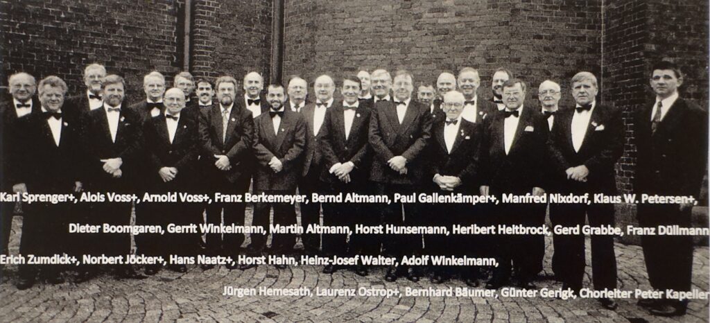 Gruppenfoto von 25 S&auml;ngern des Chors mit ihrem neuen Chorleiter Peter Kapeller im Jahr 1991.